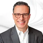 Nicholas Mitrakis headshot on white marble backround
